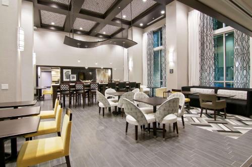 a restaurant with tables and chairs and a bar at Hampton Inn & Suites Bellevue Downtown/Seattle in Bellevue