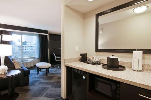 um quarto de hotel com um lavatório e um espelho grande em Hampton Inn & Suites Bellevue Downtown/Seattle em Bellevue