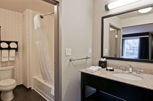 a bathroom with a sink and a toilet and a mirror at Hampton Inn & Suites Bellevue Downtown/Seattle in Bellevue