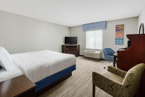 a hotel room with a bed and a chair at Hampton Inn & Suites West Sacramento in West Sacramento