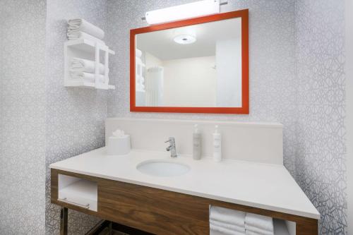 a bathroom with a white sink and a mirror at Hampton Inn & Suites West Sacramento in West Sacramento