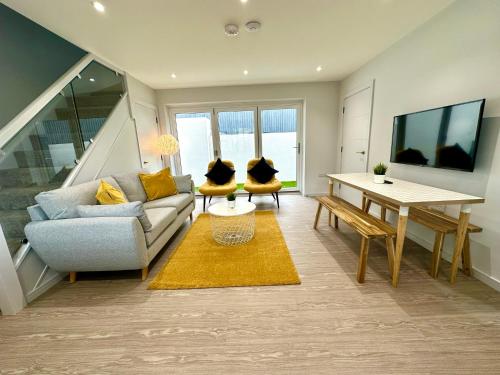 a living room with a couch and a table at Stunning Brand New House - Sleeps 6 - Free Parking - Great Location - Fast WiFi - Smart TV - Close to Poole & Bournemouth & Sandbanks in Poole