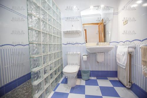 a blue and white bathroom with a toilet and a sink at Adaptados in Vinaròs