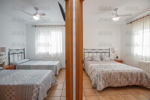ビナロスにあるAdaptadosのベッドルーム1室(ベッド2台、鏡付)