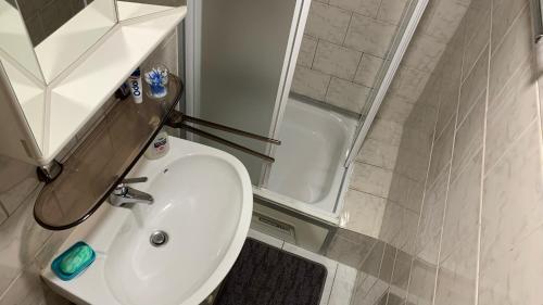 a bathroom with a white sink and a shower at Chalupa Sofia - celý objekt in Vikartovce