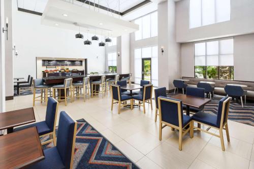 a dining room with tables and chairs and windows at Hampton Inn & Suites Thousand Oaks in Thousand Oaks