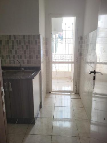 a kitchen with a sink and an open door at Complexe tamuda doha tetouan in Tétouan