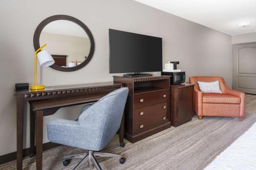 a hotel room with a desk with a television and a chair at Hampton Inn & Suites Thousand Oaks in Thousand Oaks