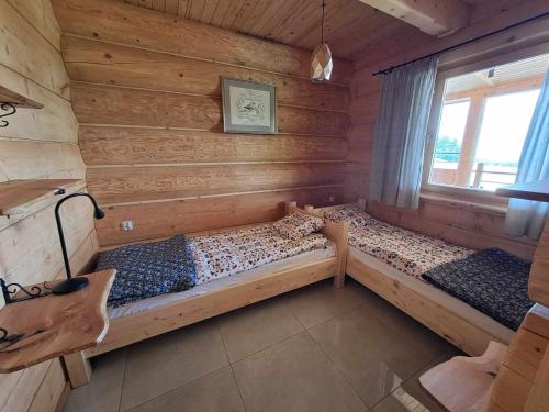 a bedroom with two beds in a log cabin at Dylewska Widokówka in Pietrzwałd