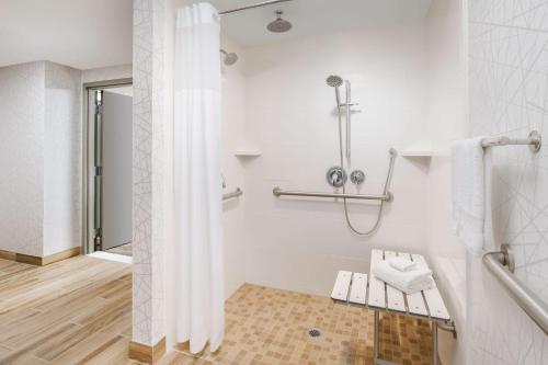 a white bathroom with a shower and a bench at Hampton Inn & Suites Thousand Oaks in Thousand Oaks