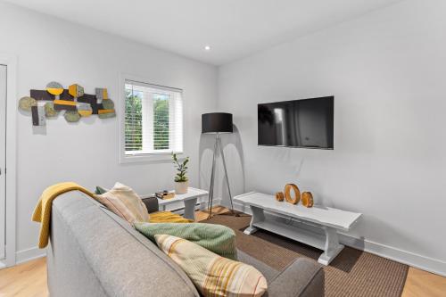 a living room with a couch and a tv at Le Karina - Vieux-Terrebonne in Terrebonne