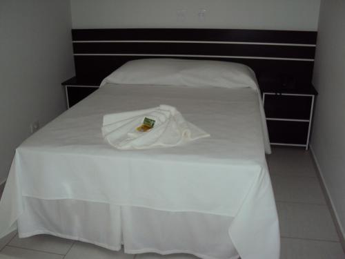 a white bed with a towel on top of it at Laf Hotel in Registro