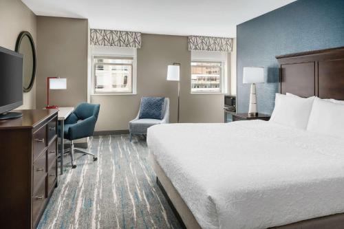 a hotel room with a bed and a desk and a television at Hampton Inn Washington DC White House in Washington