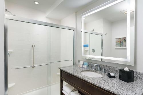 uma casa de banho com um lavatório e um chuveiro em Hampton Inn Washington DC White House em Washington