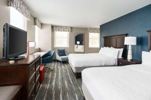 a hotel room with two beds and a flat screen tv at Hampton Inn Washington DC White House in Washington