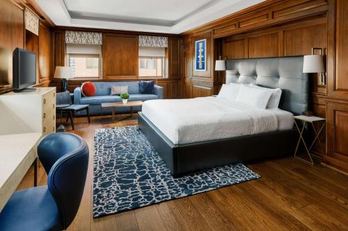 a bedroom with a bed and a couch and a television at Hampton Inn Washington DC White House in Washington, D.C.