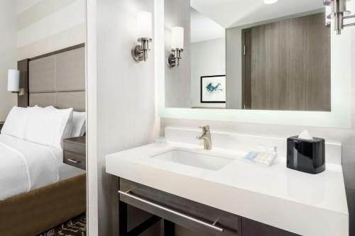a bathroom with a white sink and a bed at Homewood Suites By Hilton San Jose Santa Clara in San Jose
