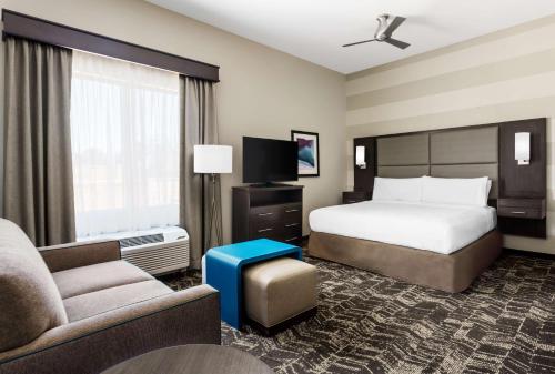 ein Hotelzimmer mit einem Bett, einem Sofa und einem TV in der Unterkunft Homewood Suites By Hilton San Jose North in San Jose