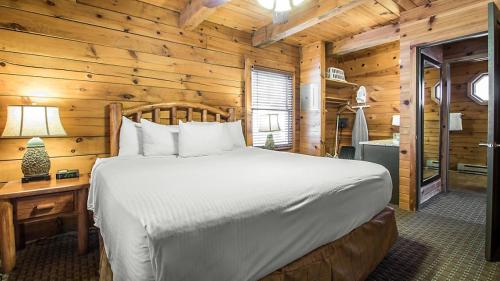 um quarto com uma cama num chalé de madeira em Christmas Mountain Campground em Wisconsin Dells