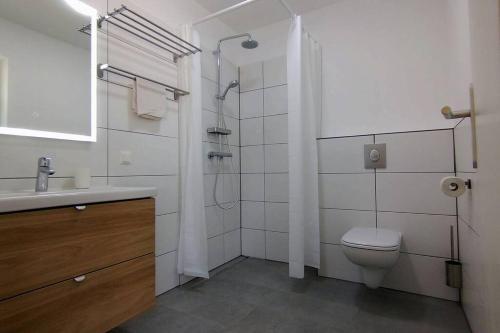 een badkamer met een toilet, een douche en een wastafel bij Geräumige Ferienwohnung mit Seezugang in Altossiach