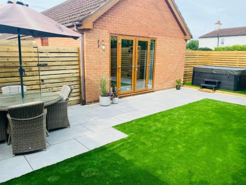 a patio with a table and an umbrella at The Red Lodge Annexe in Woodborough