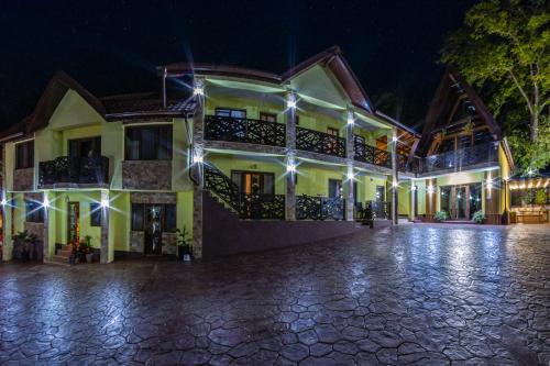 a house at night with lights on it at PENSIUNEA MIHAELA-Transalpina in Novaci