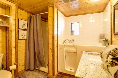 a bathroom with a tub and a shower and a sink at Broken Bow Abode with Hot Tub Less Than 7 Mi to Lake! in Broken Bow