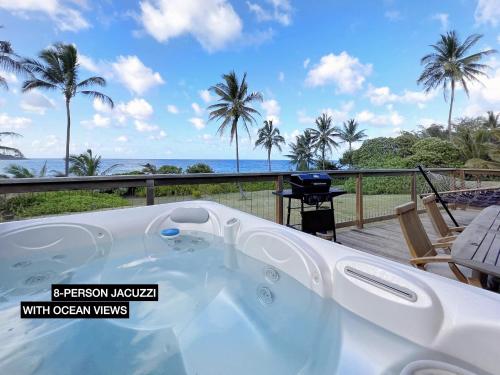 a jacuzzi tub on a deck with the ocean views at Anahola Aloha Beach House home in Anahola