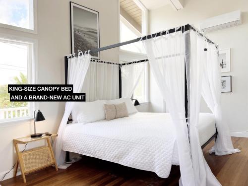 a bedroom with a canopy bed and a pyramid new ay unit at Anahola Aloha Beach House home in Anahola