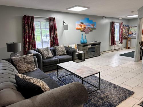 a living room with couches and a coffee table at Swiss Chalets Village Inn in North Conway