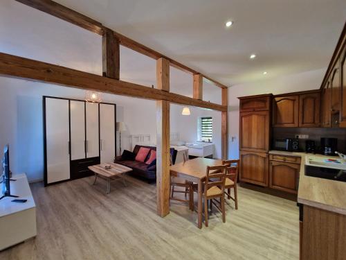 eine Küche und ein Wohnzimmer mit einem Tisch und einem Sofa in der Unterkunft Apartment auf dem Hof einer historischen Mühle in Holzhausen