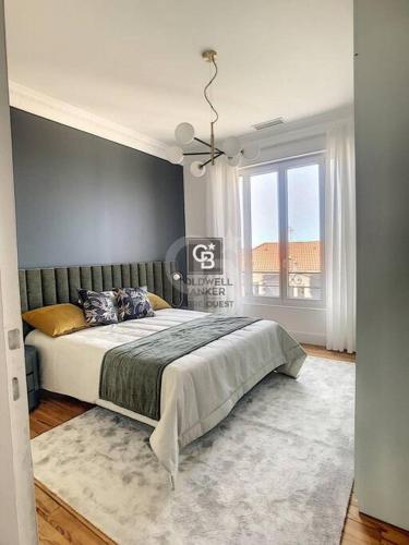 une chambre avec un grand lit et une fenêtre dans l'établissement Luxueux grand 3 chambres hypercentre calme, à Biarritz