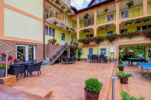 a courtyard of a hotel with tables and chairs at PENSIUNEA MIHAELA-Transalpina in Novaci