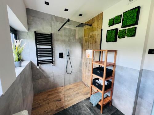 uma casa de banho com um chuveiro e uma prateleira de madeira em Retro Domek - Domek z ogrodem w górach em Sułkowice