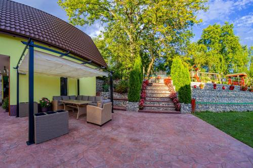 a patio with a table and chairs next to a wall at PENSIUNEA MIHAELA-Transalpina in Novaci