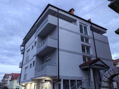 a white building with balconies on the side of it at Vila Bolonja in Struga