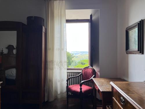 Zimmer mit einem Stuhl und einem Fenster in der Unterkunft Castello ala Lucia in Monte Roberto