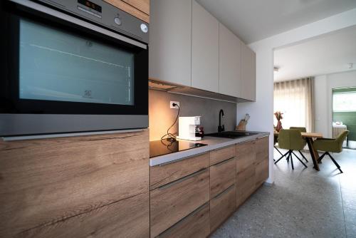 a kitchen with a large flat screen tv on the wall at Apartments Kras 24 with Pool in Sežana