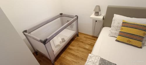 Una cama blanca con marco de metal en un dormitorio en Rest apartment Cerknica, en Cerknica