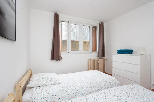 um quarto com 2 camas e 2 janelas em Le Blanc-Mesnil parc des expos F2 Rez de Jardin 23B RDC DERRIERE em Le Blanc-Mesnil