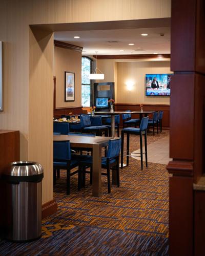 a hotel room with tables and chairs and a dining room at Courtyard Boston Copley Square in Boston
