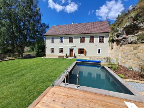 a house with a swimming pool in front of a yard at Chalupa Zátyní - celý objekt in Dubá