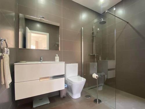 a bathroom with a toilet and a glass shower at VILLA ALICIA by JK Lanzarote in Puerto del Carmen