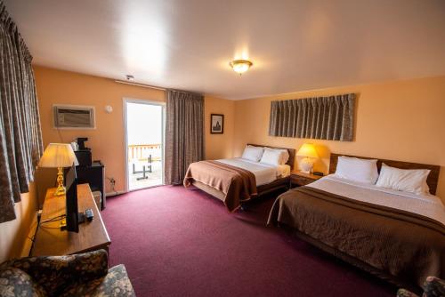 a hotel room with two beds and a window at Bells Melody Motel in Mackinaw City