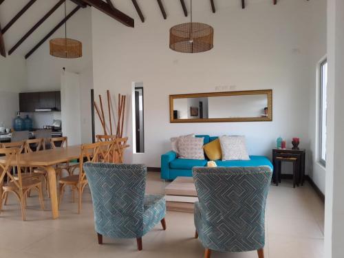 a living room with a blue couch and a table at CASA CAMPESTRE COMPLETa in Barbosa