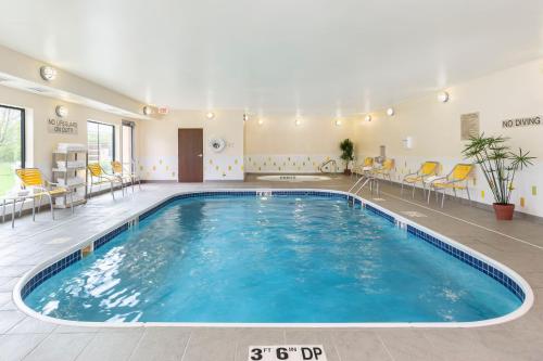 a large swimming pool in a room with chairs and tables at Fairfield Inn & Suites Springfield in Springfield