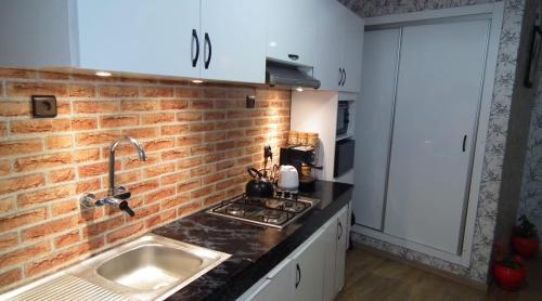 cocina con fregadero y pared de ladrillo en StayHere, Nice Apartment with Garden View in center, 1 min walk From Beach en El Jadida