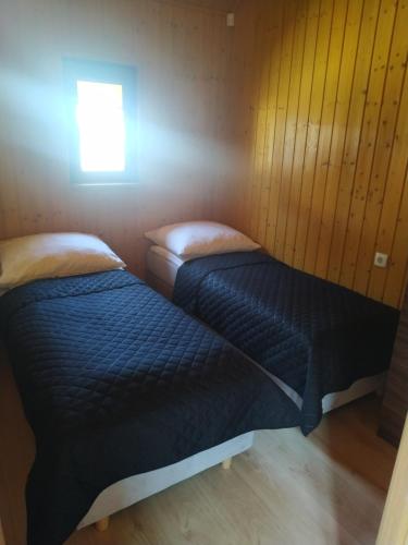 2 łóżka w małym pokoju z oknem w obiekcie Domek letniskowy we Władysławowie