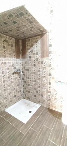 uma casa de banho com chuveiro e azulejos no chão em One bedroom apartment em Salé