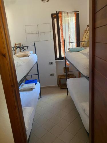 a room with three bunk beds and a window at House pinus village in Forte Village